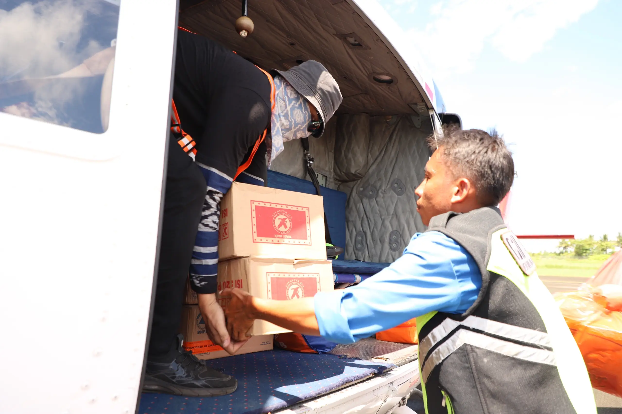 Proses loading bantuan logistik yang didistribusikan melalui helikopter pada penanganan darurat banjir dan tanah longsor di Kabupaten Luwu, Sulawesi Selatan, Selasa (7/5).
